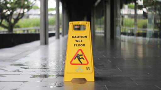 yellow Caution wet floor signage on wet pavement
