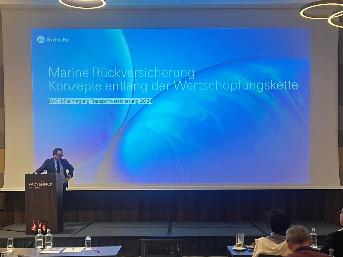 Ein Mann steht auf der Bühne und referiert