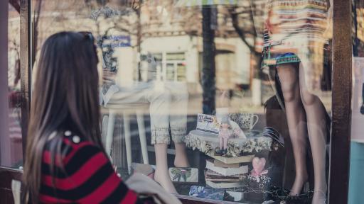 Frau vor Schaufenster Kleiderladen